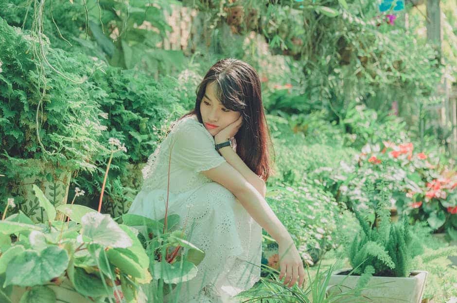 woman squatting in her backyard garden